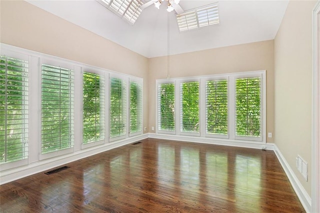 spare room featuring a high ceiling, a ceiling fan, plenty of natural light, and wood finished floors