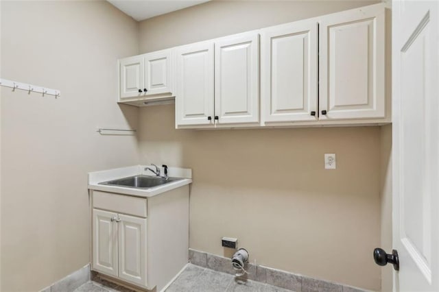 laundry area featuring cabinet space and baseboards