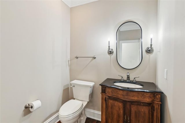 half bath featuring toilet, vanity, and baseboards