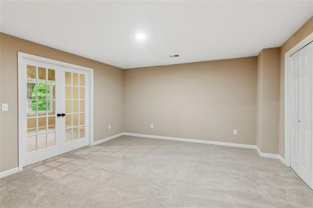 unfurnished room featuring light colored carpet, baseboards, and french doors