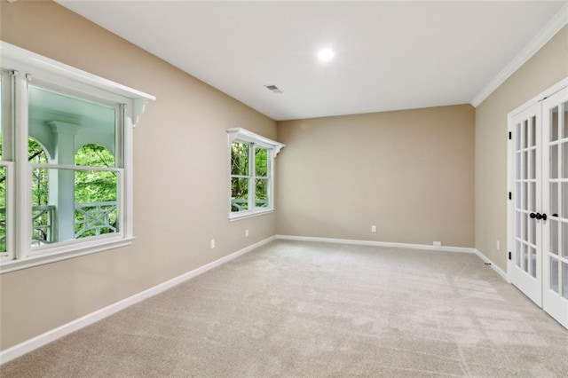 carpeted spare room with baseboards, french doors, and ornamental molding