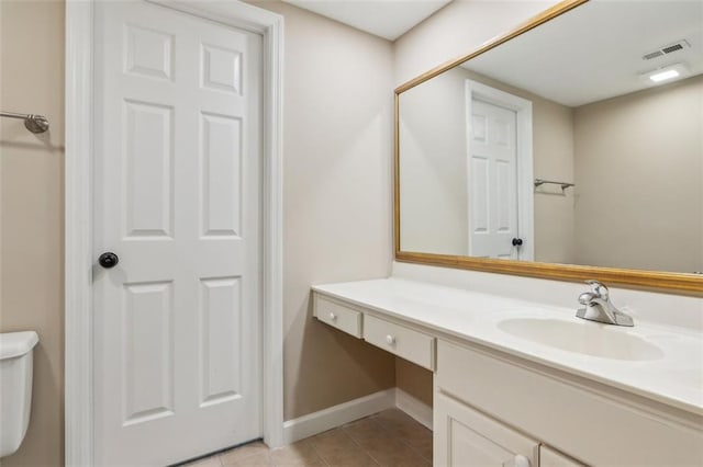 bathroom with vanity, tile patterned flooring, baseboards, and toilet