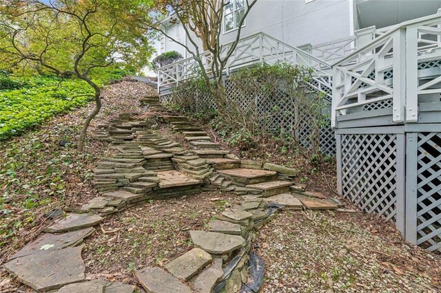 back of property featuring a balcony, stucco siding, french doors, and a shingled roof