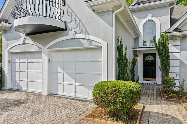 property entrance featuring decorative driveway and stucco siding