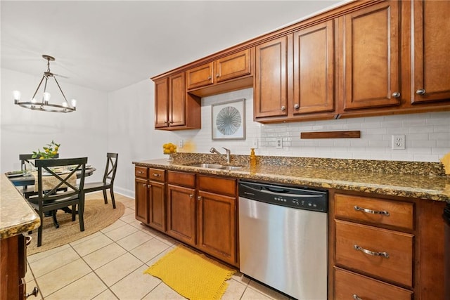 kitchen featuring backsplash, an inviting chandelier, brown cabinetry, light tile patterned floors, and dishwasher