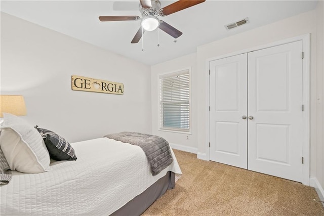 bedroom with visible vents, light carpet, baseboards, and ceiling fan