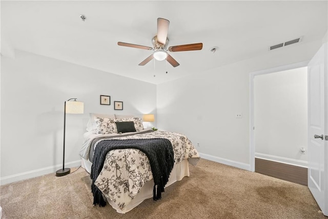 carpeted bedroom featuring a ceiling fan, baseboards, and visible vents