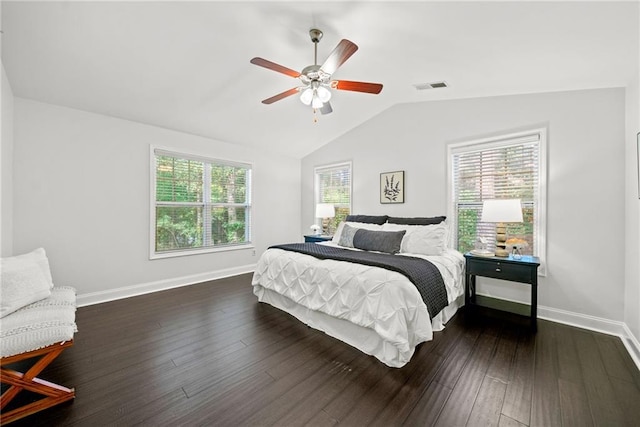 bedroom with visible vents, multiple windows, dark wood-type flooring, and vaulted ceiling