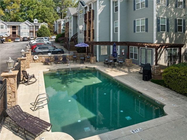 community pool featuring french doors, a residential view, fence, and a patio area