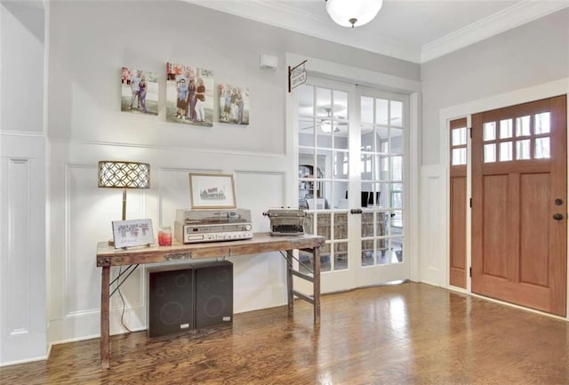 foyer entrance featuring crown molding, ceiling fan, wood finished floors, and a decorative wall