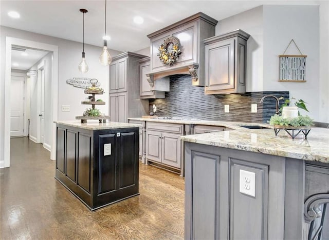 kitchen with a sink, pendant lighting, gray cabinets, and tasteful backsplash