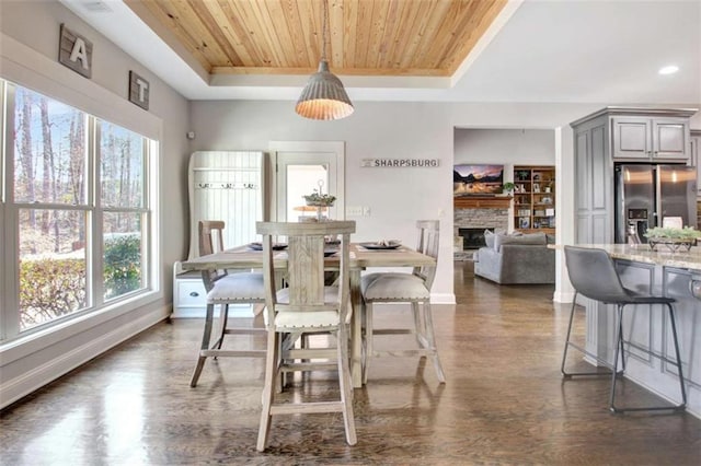 dining room with plenty of natural light, wood ceiling, a tray ceiling, and dark wood-style floors