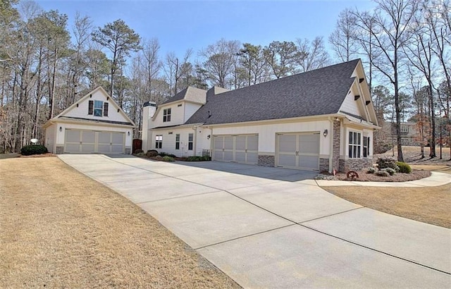 view of front of home with a shingled roof, concrete driveway, and stone siding