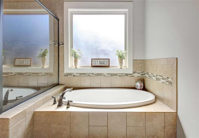 bathroom featuring a bath, a wealth of natural light, and tiled shower