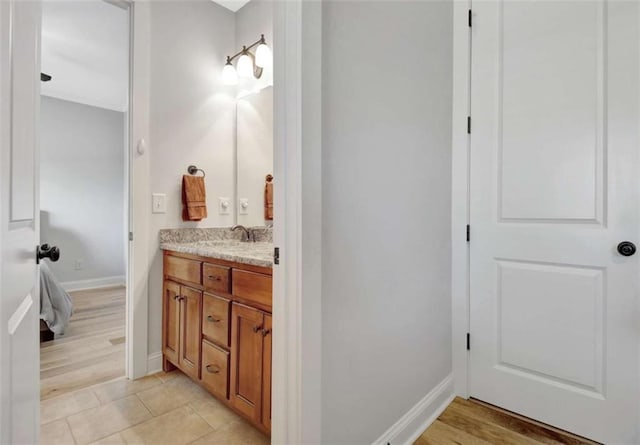 bathroom featuring baseboards, tile patterned flooring, and vanity