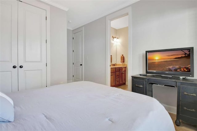 bedroom featuring crown molding, a closet, and ensuite bath