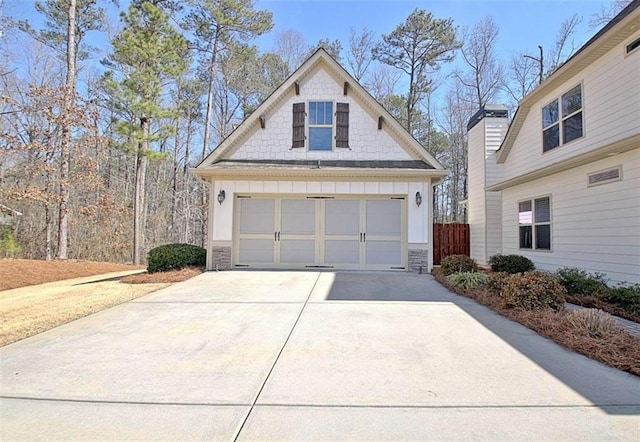 view of front of house featuring board and batten siding, driveway, and stone siding