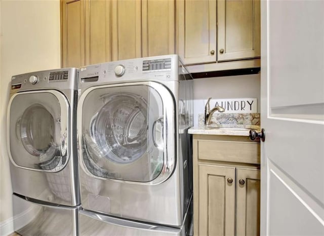 washroom with a sink, independent washer and dryer, and cabinet space