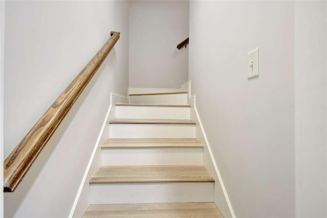 stairs featuring wood finished floors