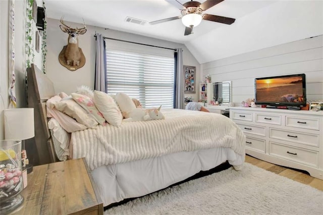bedroom featuring visible vents, a ceiling fan, light wood finished floors, and lofted ceiling