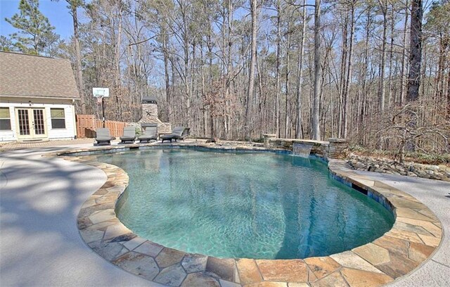 outdoor pool featuring a patio and french doors