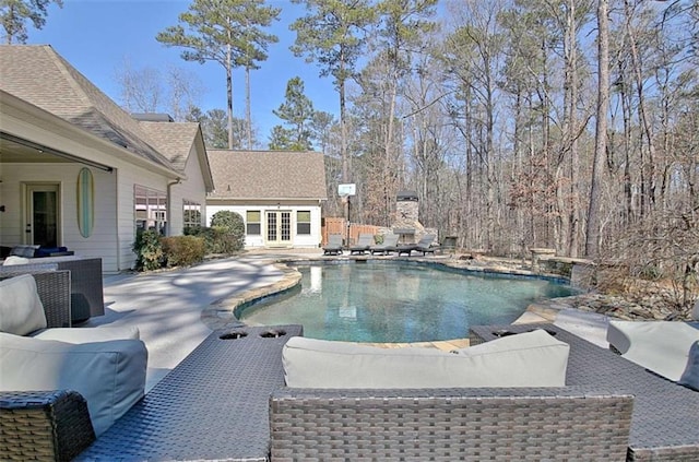 outdoor pool with a patio and french doors