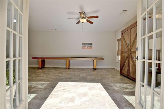 unfurnished room with visible vents, a ceiling fan, and baseboards