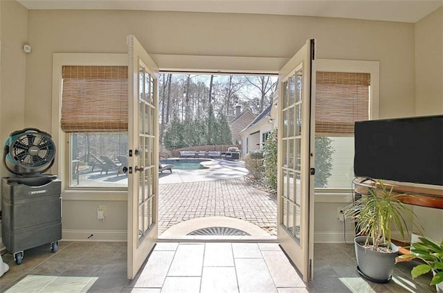 doorway with baseboards, a healthy amount of sunlight, and french doors