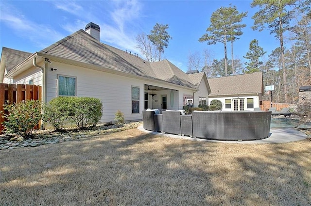 back of house with fence, french doors, a pool, and a chimney