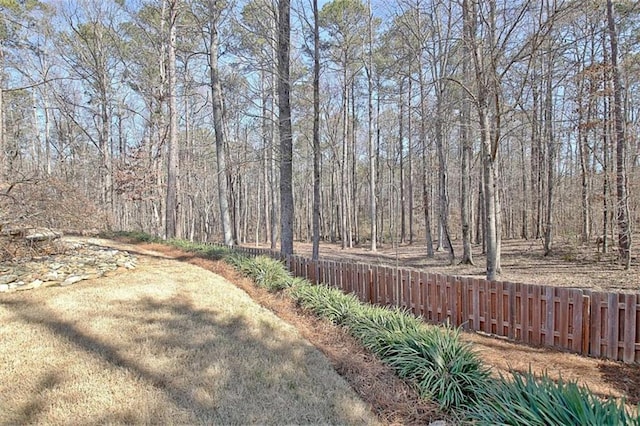 view of yard with a view of trees and fence