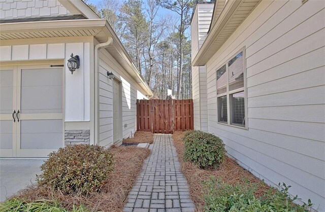 view of side of property with board and batten siding and fence