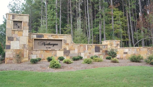 community / neighborhood sign with a yard