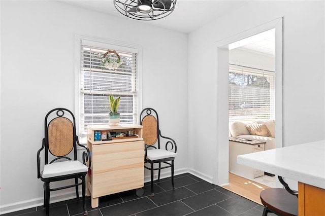 living area featuring dark tile patterned floors and baseboards