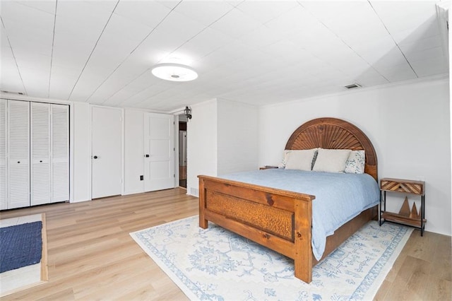 bedroom with visible vents and wood finished floors