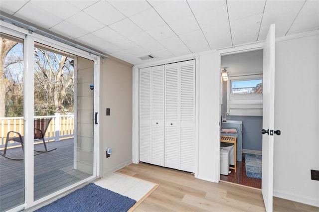 doorway to outside with baseboards, visible vents, and wood finished floors