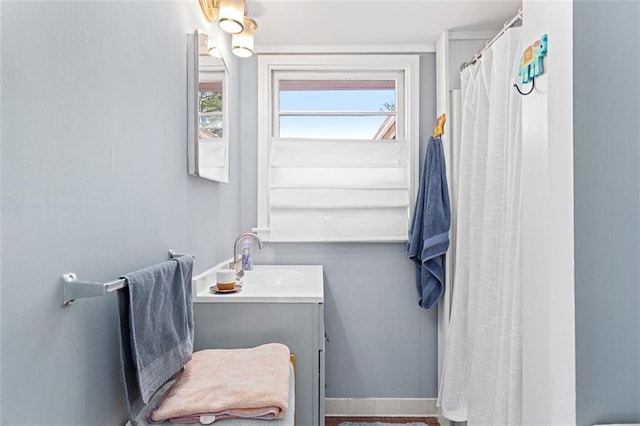 full bathroom featuring a shower with curtain, vanity, and baseboards