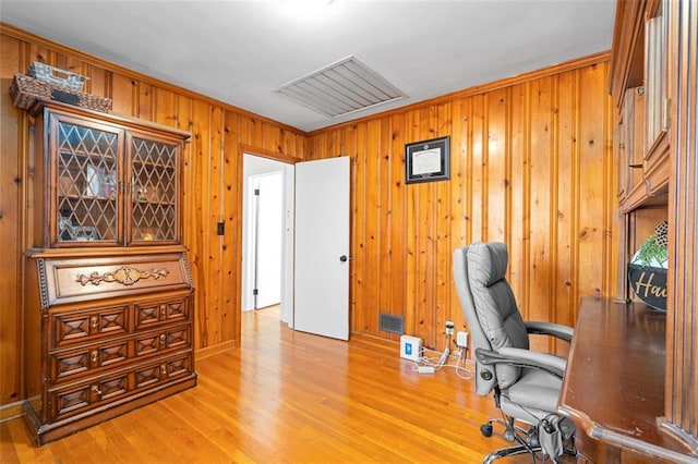 office space with wooden walls, visible vents, and wood finished floors