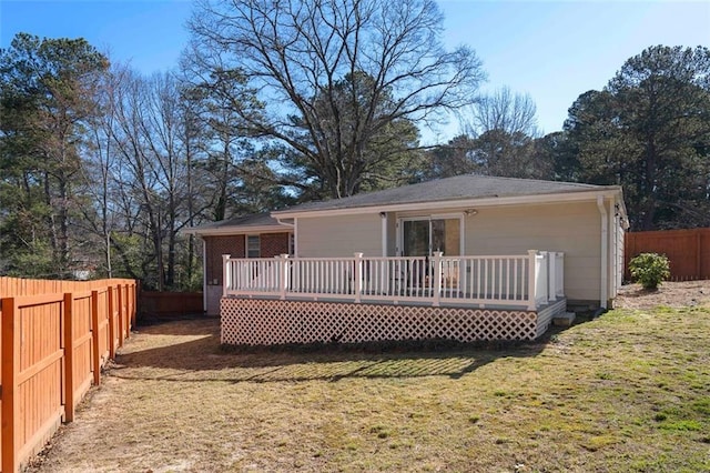 back of property featuring a fenced backyard, a lawn, and a wooden deck