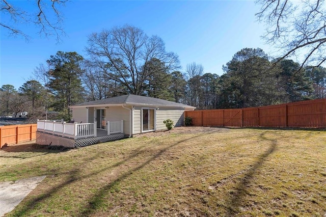 back of house featuring a fenced backyard, a deck, and a lawn