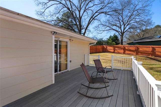 wooden terrace with a fenced backyard and a lawn