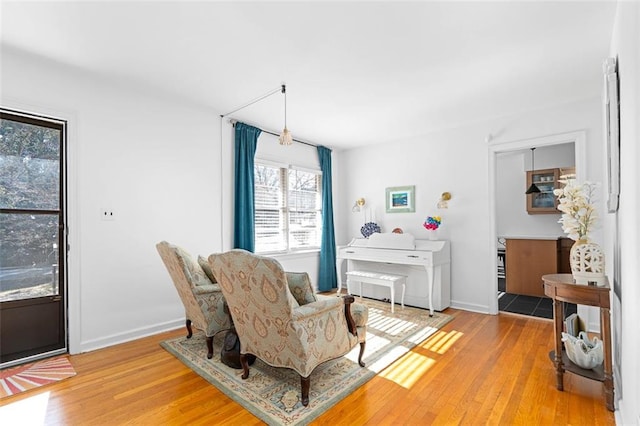 living area with light wood-type flooring and baseboards