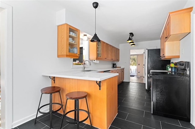 kitchen featuring glass insert cabinets, a sink, washer / dryer, a peninsula, and a kitchen bar