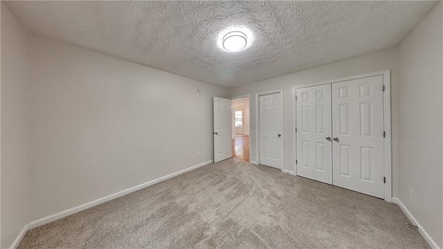 514 Jadetree Ln, Atlanta, GA 30349 - unfurnished bedroom featuring carpet flooring, baseboards, a textured ceiling, and multiple closets