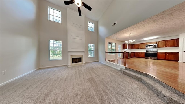 514 Jadetree Ln, Atlanta, GA 30349 - unfurnished living room with a chandelier, ceiling fan, a towering ceiling, baseboards, and light carpet