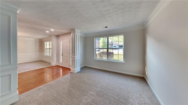 514 Jadetree Ln, Atlanta, GA 30349 - carpeted empty room with decorative columns, crown molding, healthy amount of natural light, a textured ceiling, and baseboards