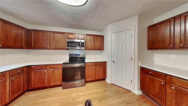514 Jadetree Ln, Atlanta, GA 30349 - kitchen with stainless steel appliances, light wood-style floors, light countertops, a textured ceiling, and brown cabinets