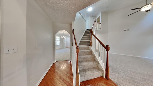 514 Jadetree Ln, Atlanta, GA 30349 - stairway with arched walkways, ceiling fan, baseboards, a textured ceiling, and a chandelier