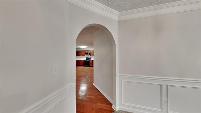 514 Jadetree Ln, Atlanta, GA 30349 - corridor with arched walkways, wood finished floors, a textured ceiling, wainscoting, and ornamental molding
