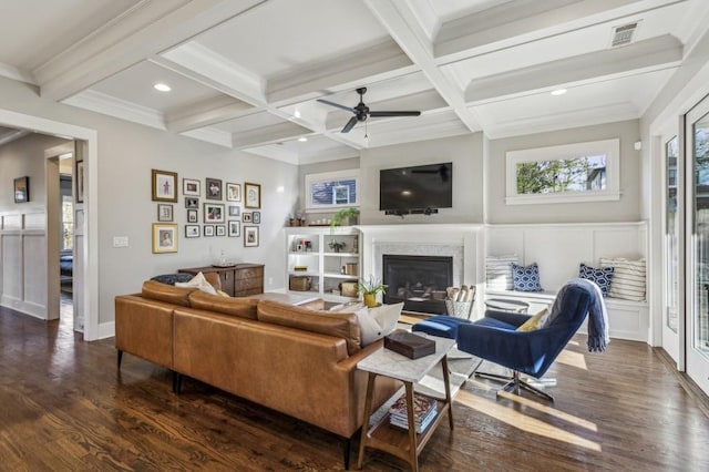 living room with visible vents, coffered ceiling, beam ceiling, dark wood-type flooring, and a glass covered fireplace