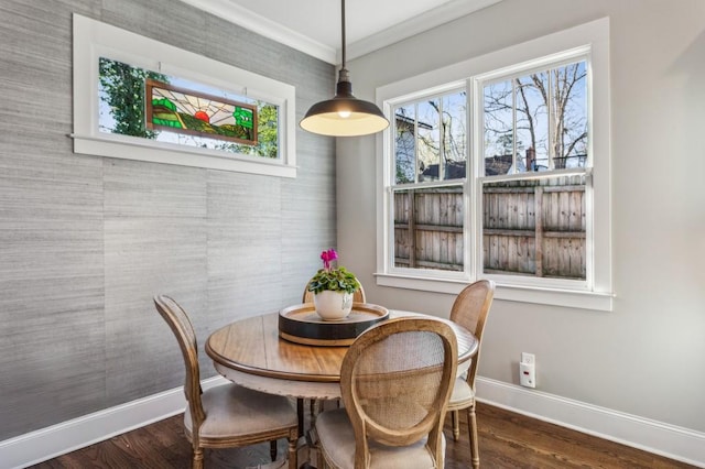 dining space with baseboards, wood finished floors, and ornamental molding